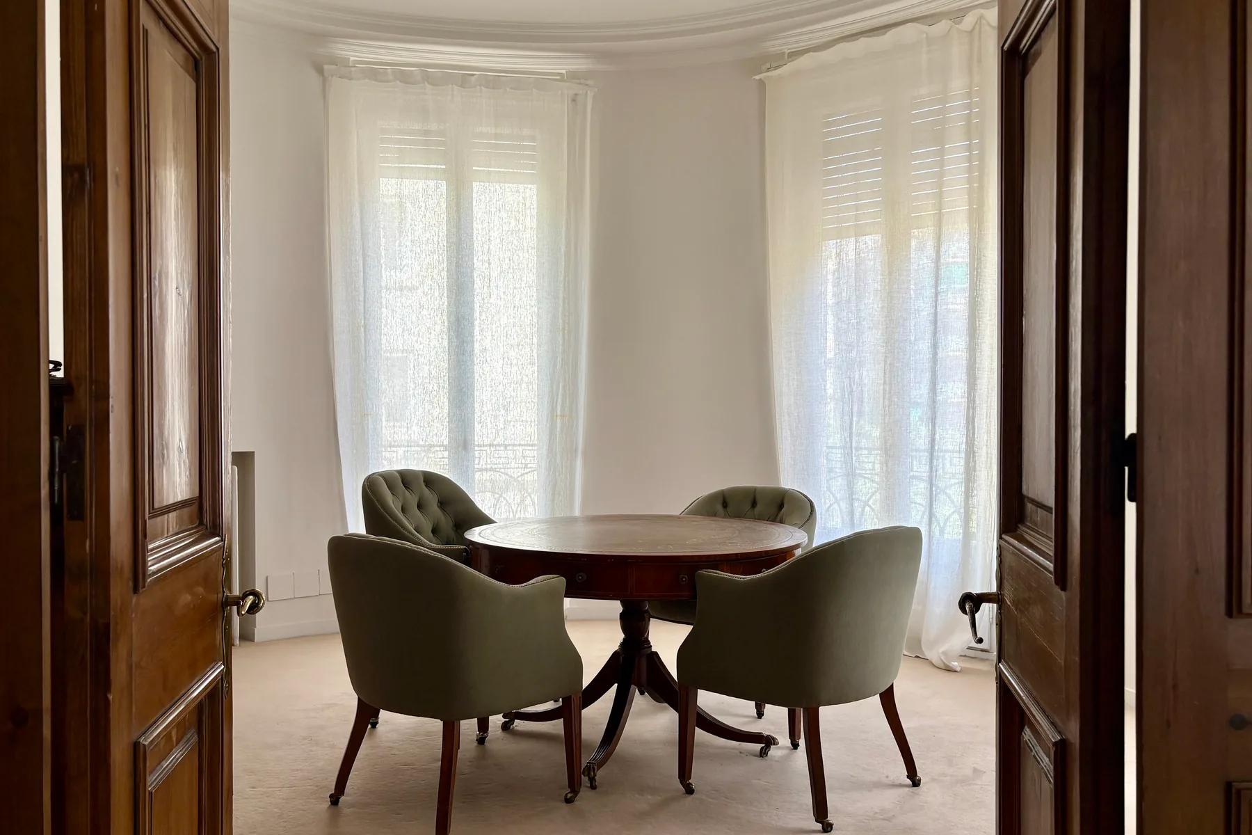 Sala del mirador, amb taula rodona i butaques, il·luminada per finestrals